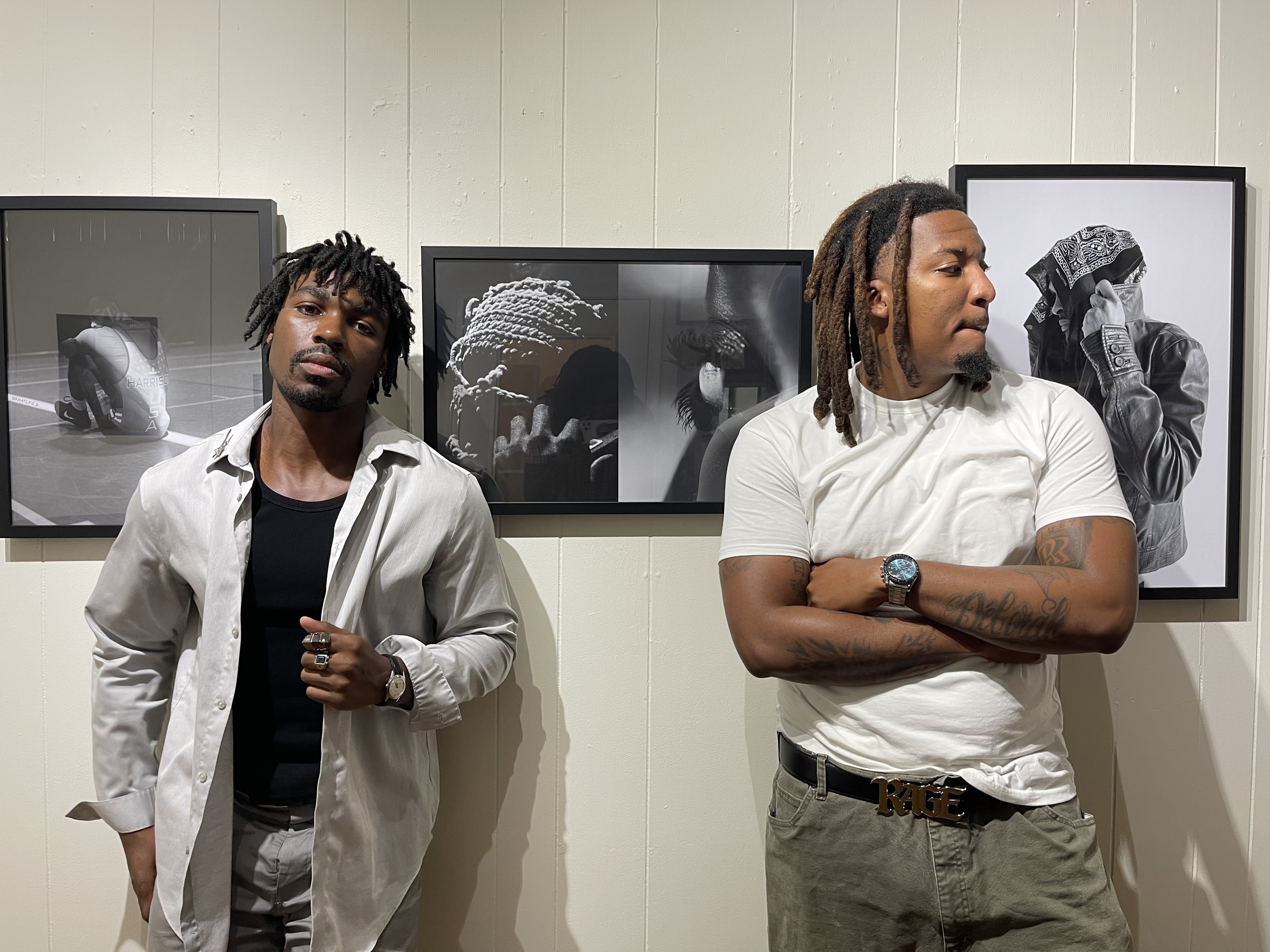 Photographers Ezra and ThirdEye pose in front of their work at the "Nearsighted" gallery